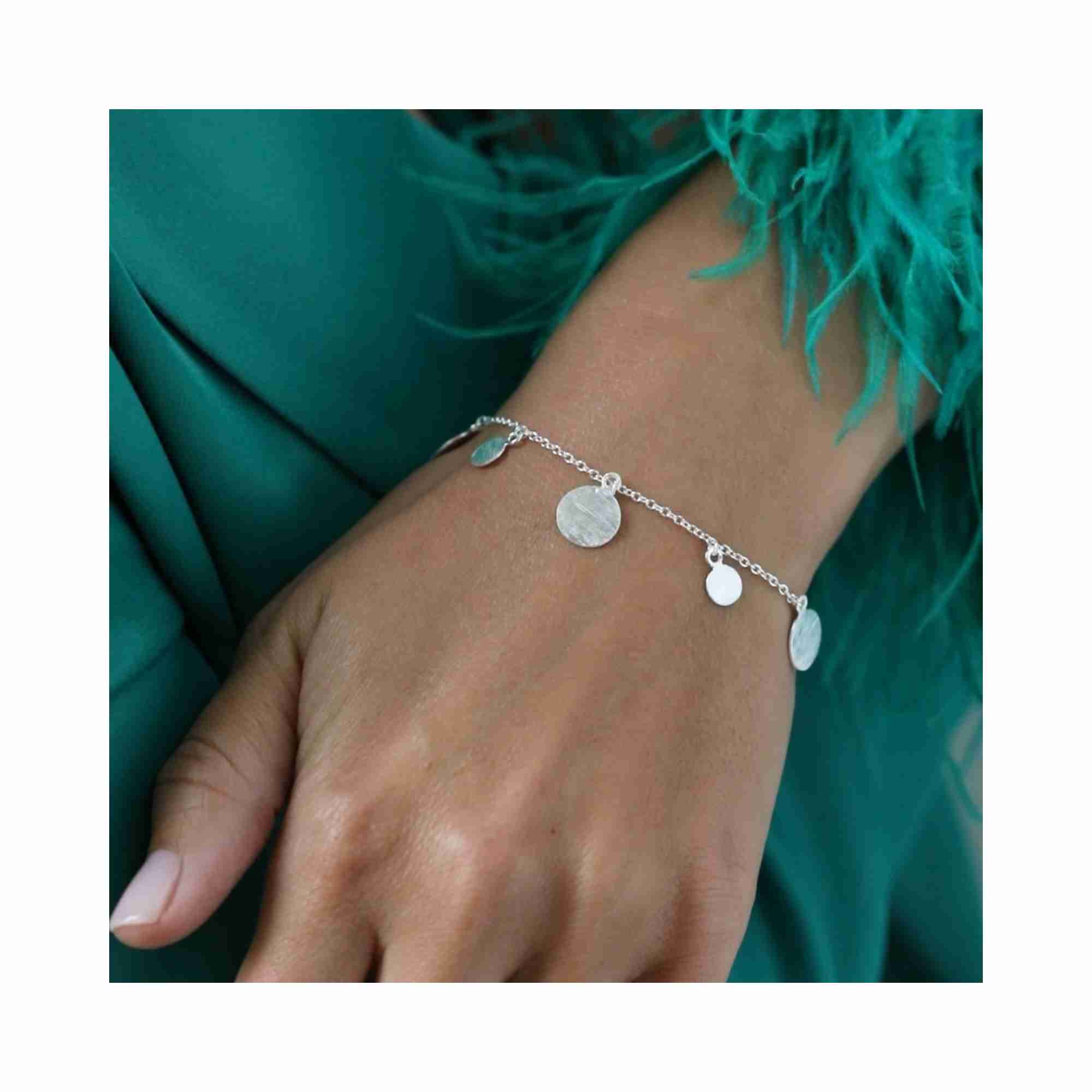 Editorial model photoshoot of the Shimmering Disks Delicate Chain Bracelet Silver, showcasing the minimalist graduating disk design on the wrist in 92.5 recycled silver — Protsaah Zurich.