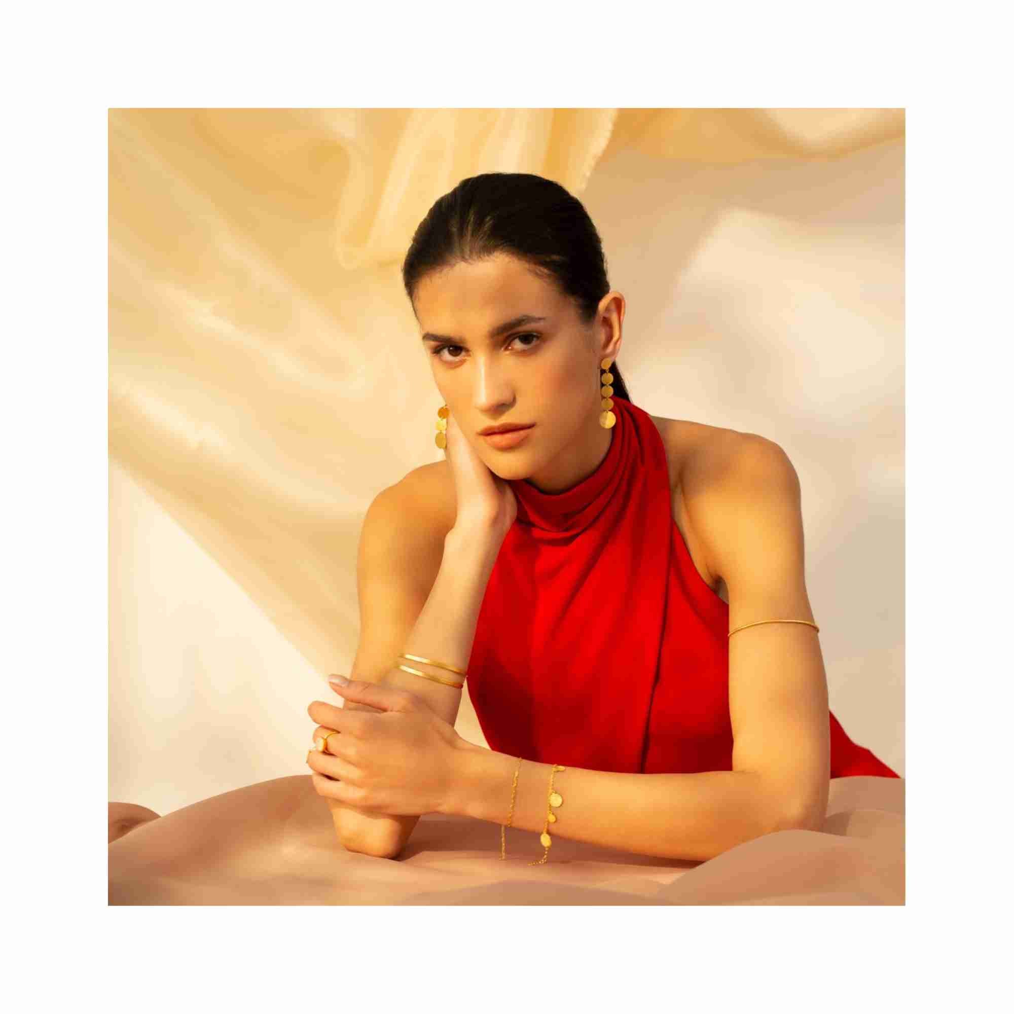 Editorial model photoshoot of the Shimmering Disks Sculptural Flat-Band Double Cuff Gold, showcasing the bold architectural open-cuff design and hand-brushed matte 22K gold vermeil finish — Protsaah Zurich.