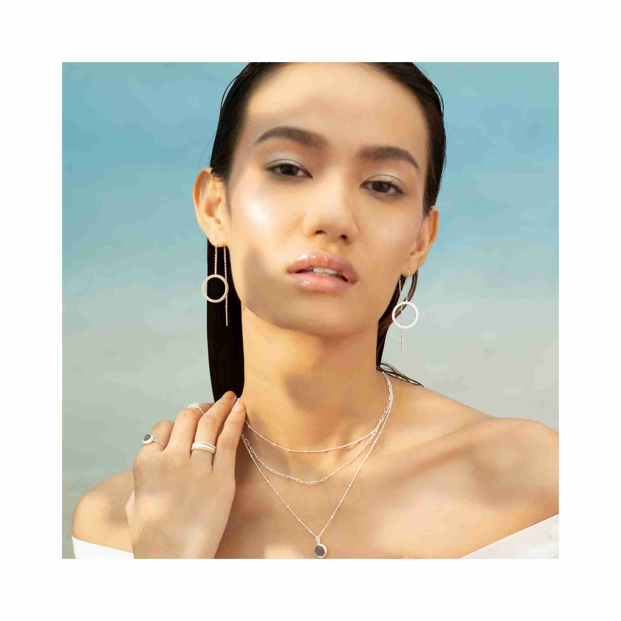 Editorial model photoshoot featuring Shimmering Disks circle chain threader earrings in 92.5 recycled silver, highlighting the elegant long-drop silhouette and minimalist architectural design — Protsaah Zurich.