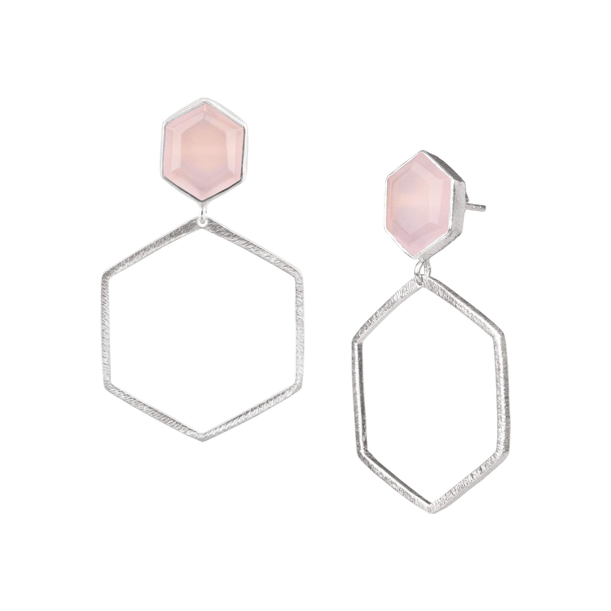 Product photography of Geo Glam Hexagonal Pink Chalcedony Statement Earrings Silver, highlighting the faceted pastel pink gemstone suspended inside a large, open hexagonal drop frame below a hand-textured matte silver post — Protsaah Zurich.