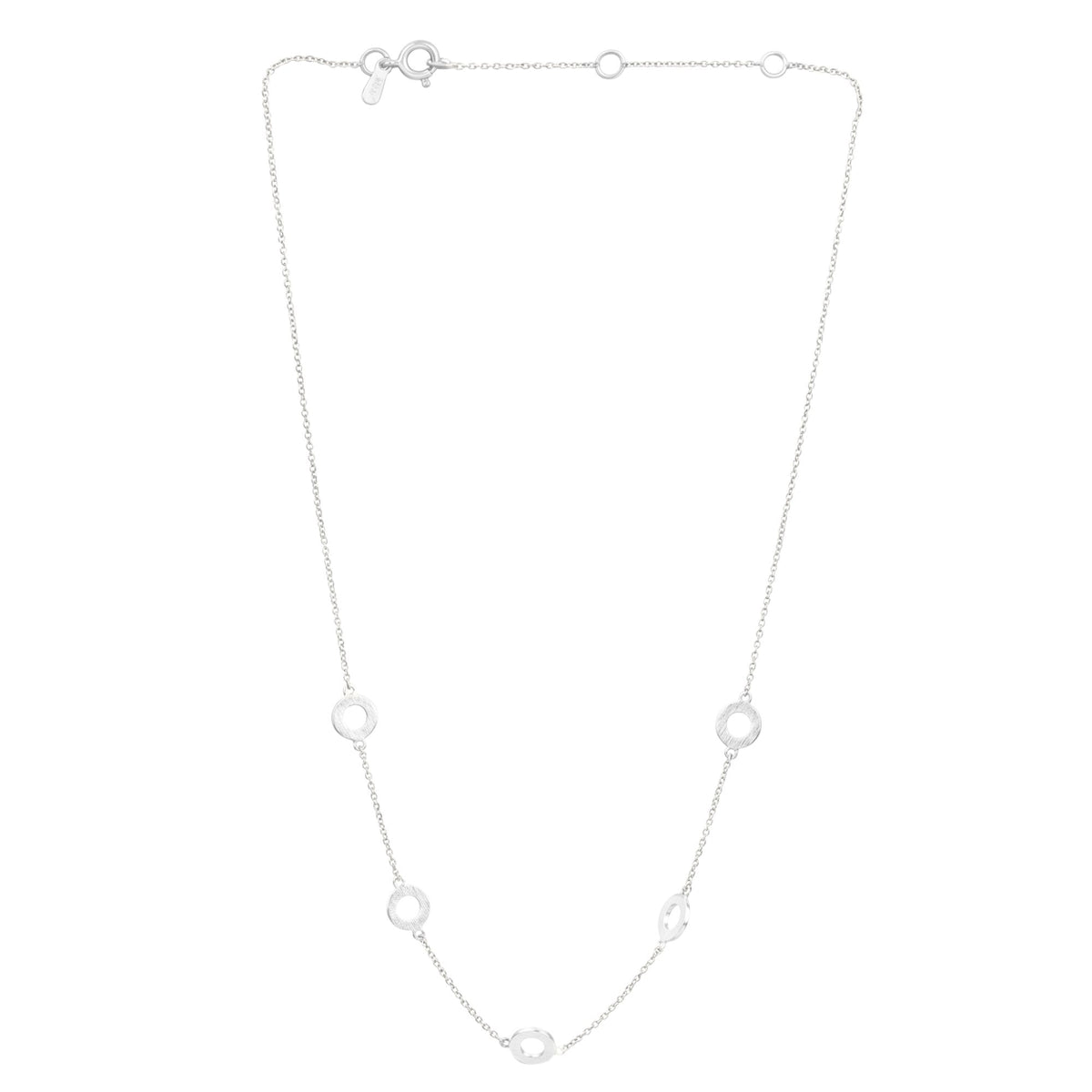 Close-up of five hand-brushed silver open circles linked along a fine chain