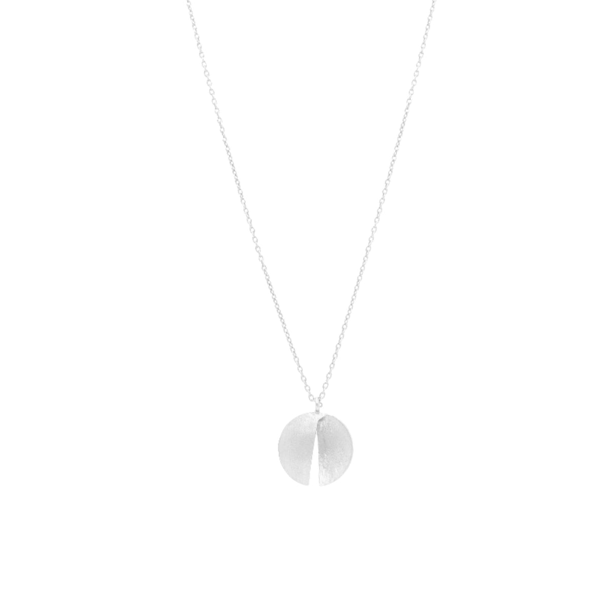 Close-up of the folded silver split-disc pendant showing its hand-brushed surface and central slit