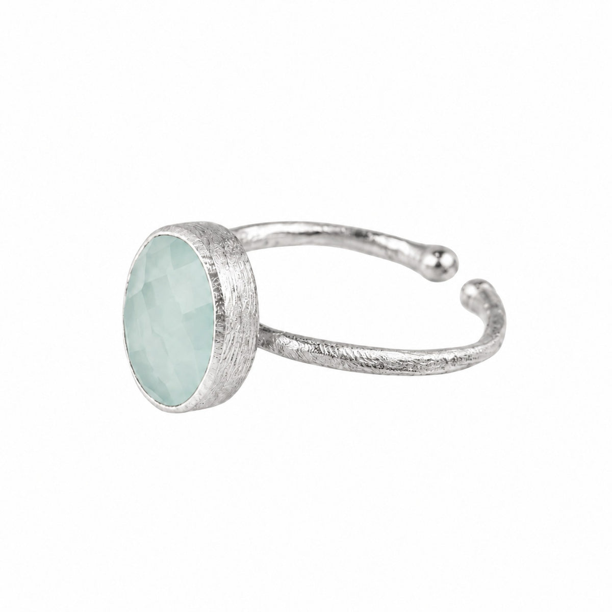 Faceted aqua chalcedony oval in a brushed silver collet on a hammered open silver band on a white background