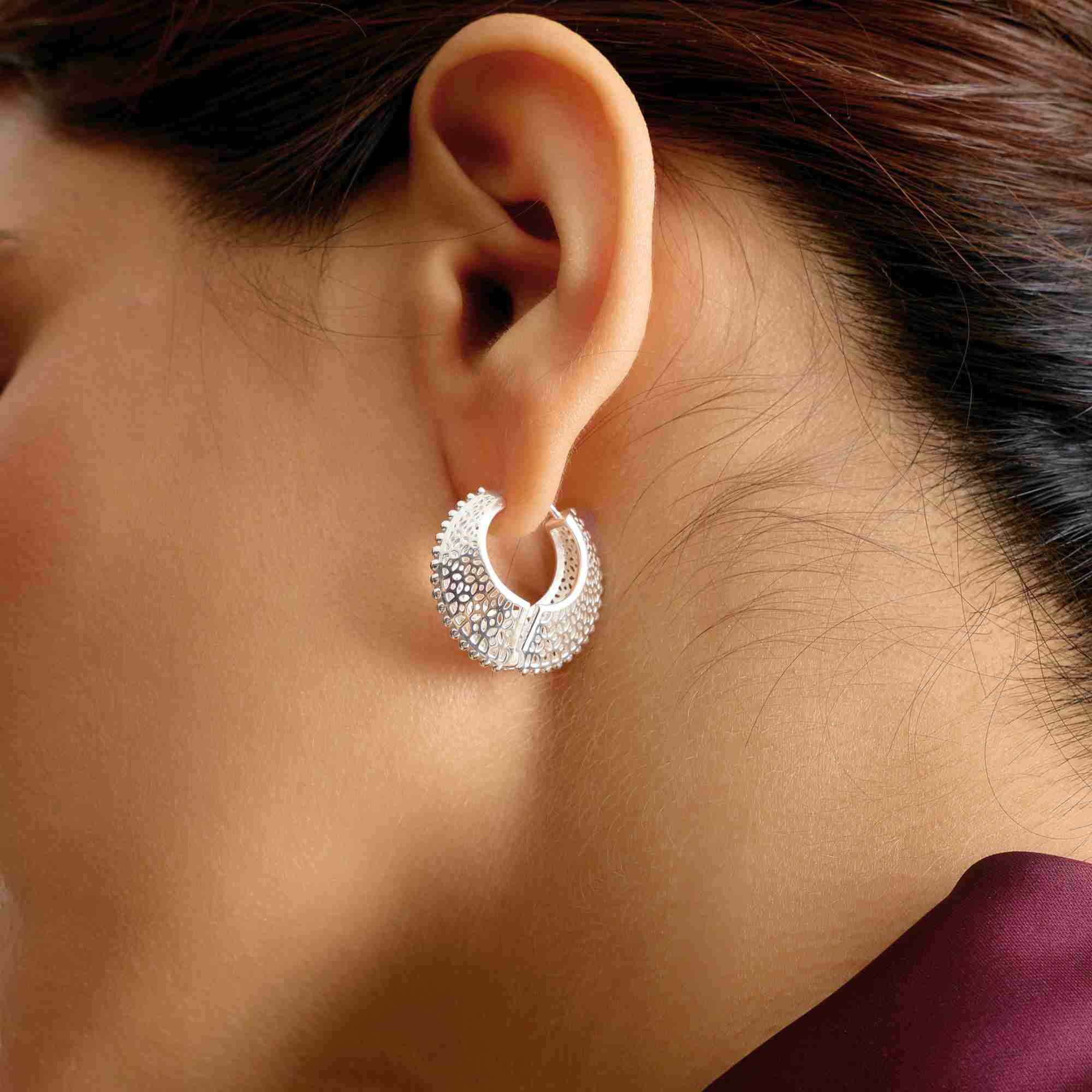 Side profile view named Ribbon & Lace showing a model wearing the Ribbons & Lace Filigree Sculptural Hoop Earrings Silver, highlighting the detailed filigree metalwork, scalloped borders, and secure latch closure of the crescent-shaped hoop earring by Protsaah Zurich.