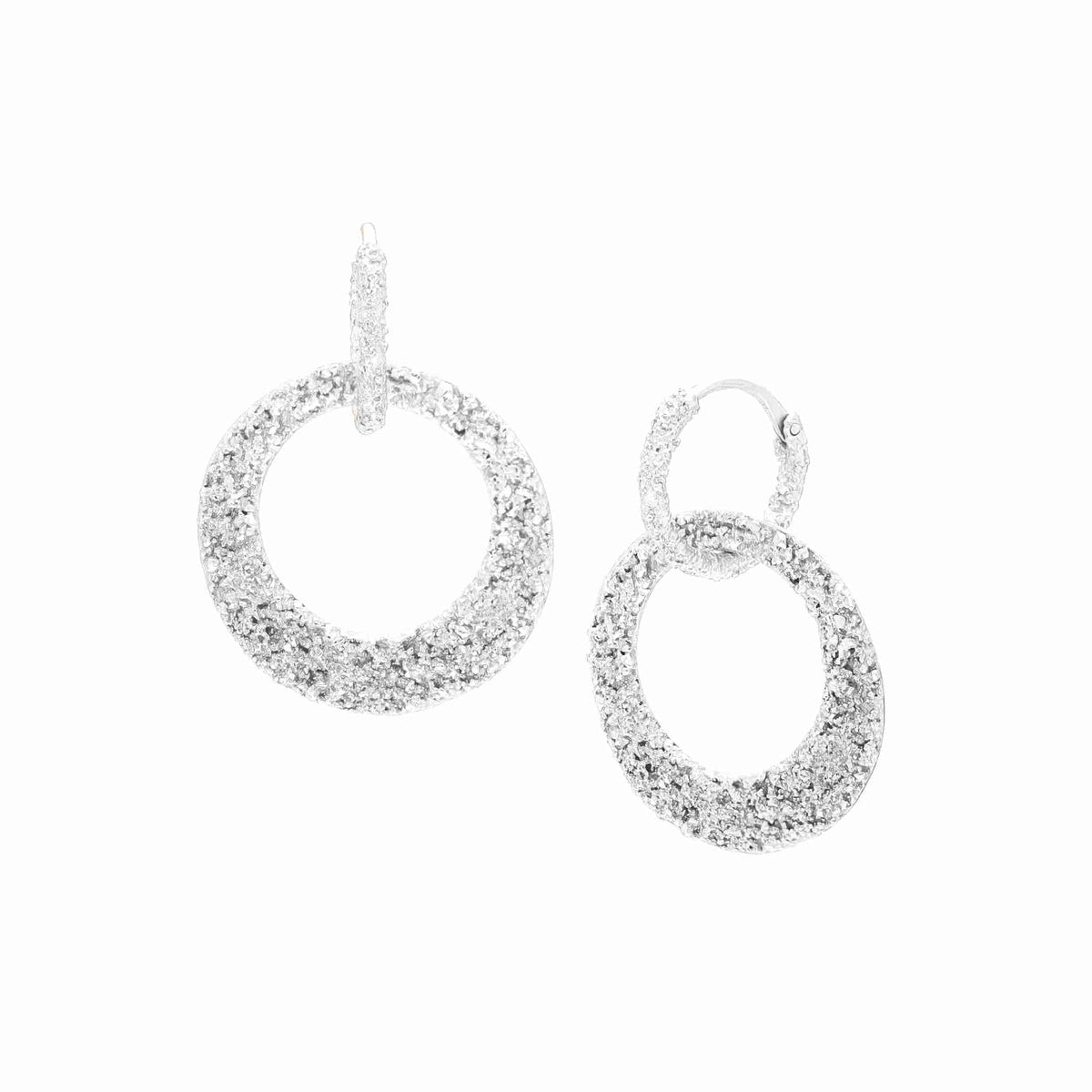 Textured huggie hoop with a large open circle drop in silver on a white background