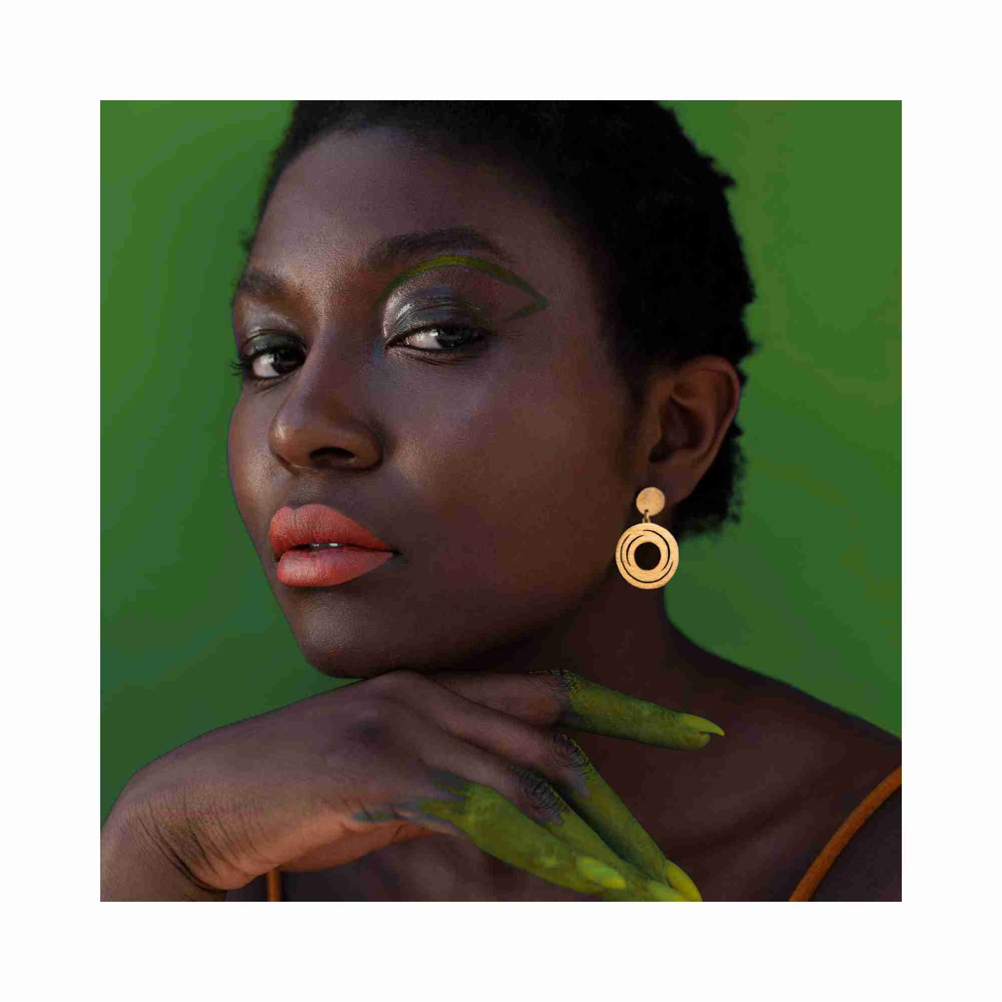 Editorial model photoshoot showcasing the Shimmering Disks Orbital Swirl Drop Statement Earrings in 22K gold vermeil, featuring an architectural concentric design styled for a modern, high-fashion look — Protsaah Zurich.