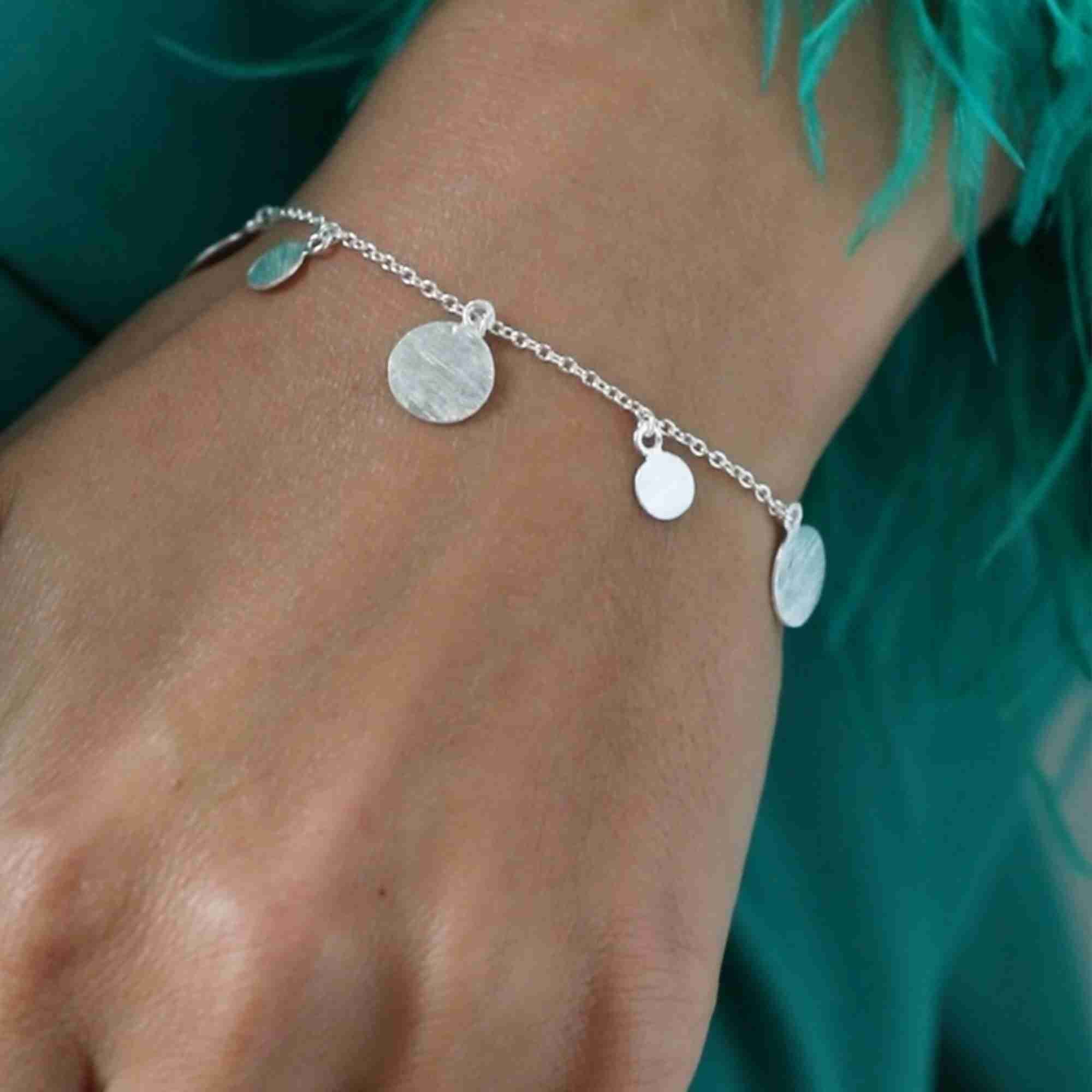 Detailed close-up photo of the Shimmering Disks Delicate Chain Bracelet Silver centerpiece, showcasing the small circular silver disc charm with its fine hand-brushed matte finish.