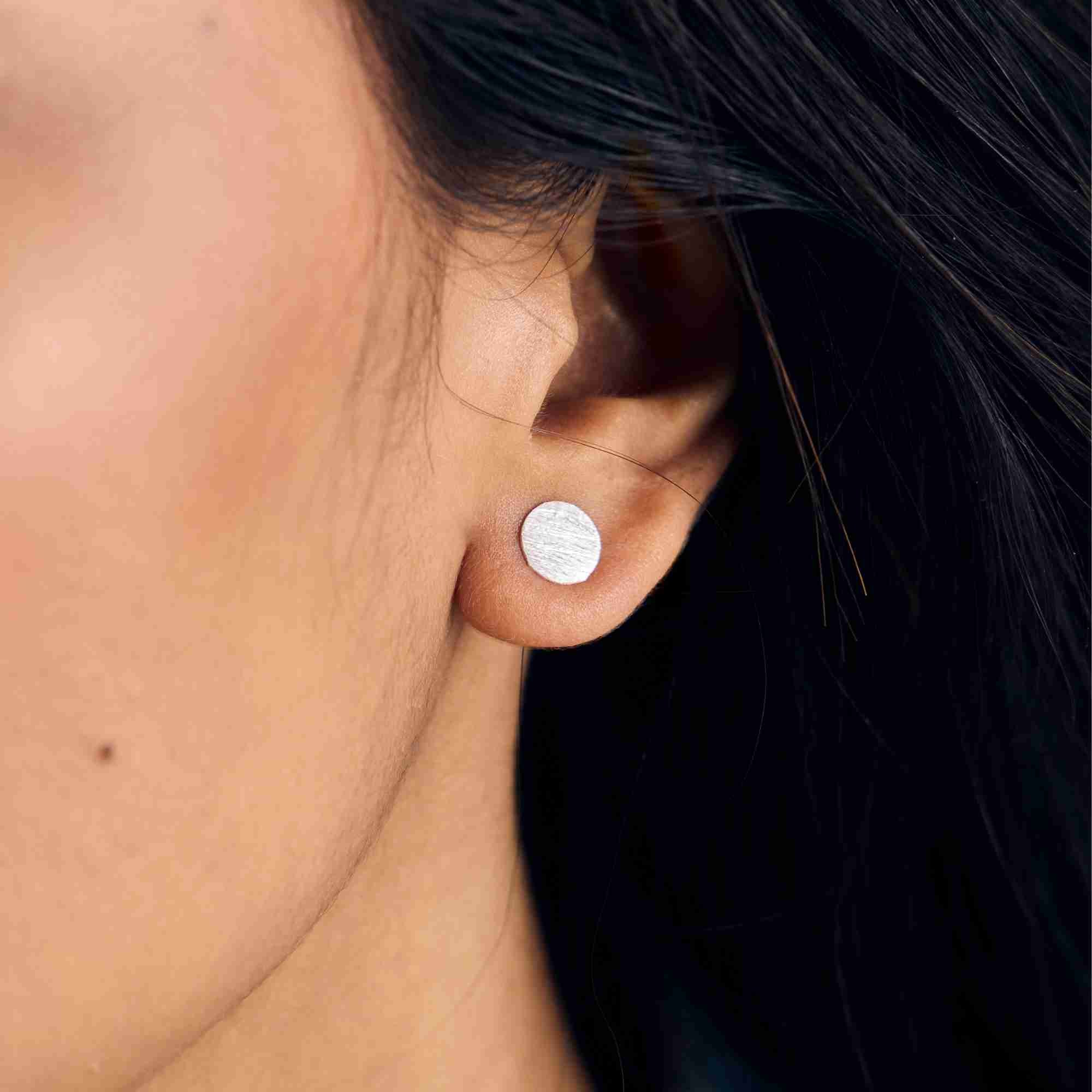 Shimmering Disks Silver Stud Earrings crafted from recycled 925 silver with a minimalist circular silhouette and signature hand-applied scratch finish.