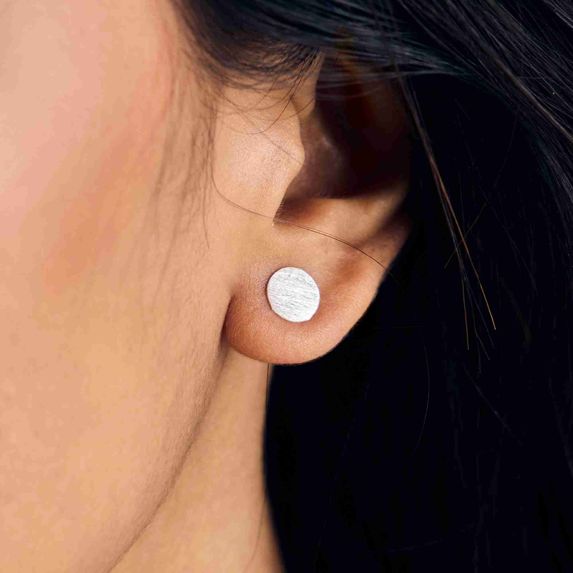Shimmering Disks Silver Stud Earrings crafted from recycled 925 silver with a minimalist circular silhouette and signature hand-applied scratch finish.