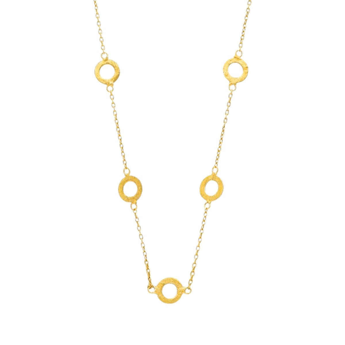 Close-up of five hand-brushed gold open circles linked along a fine chain
