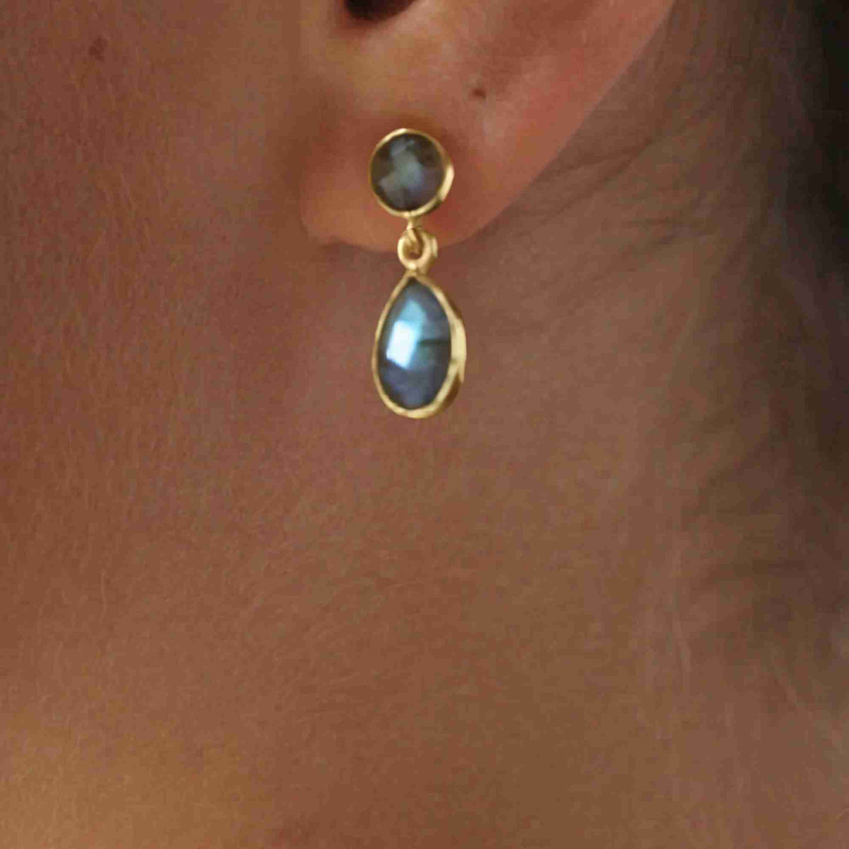 Model wearing gold labradorite teardrop stud drop earrings, close-up on the ear