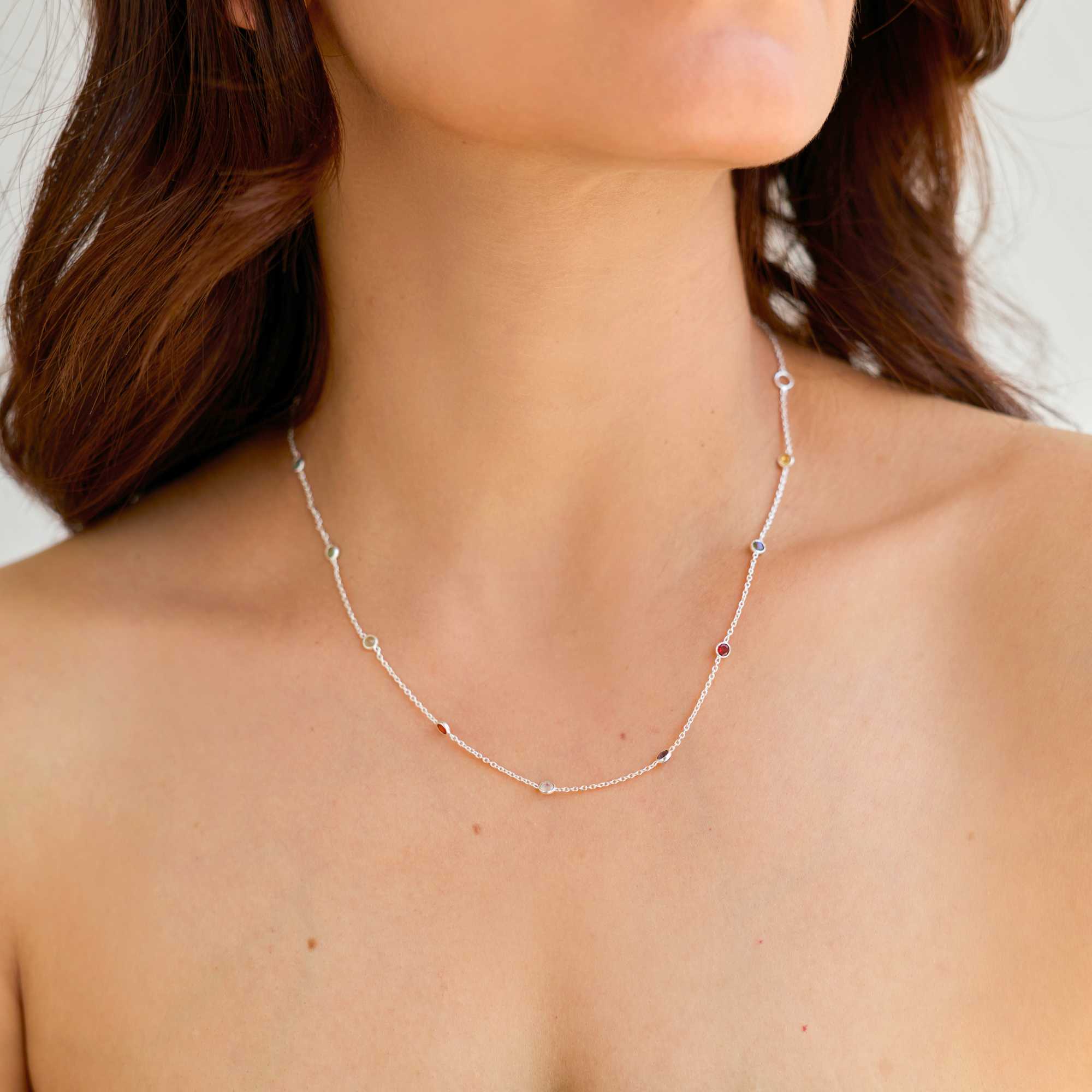 Model wearing Protsaah Zurich Dew Drops multi-gemstone dotted short necklace in 92.5 recycled silver, showing how the multicolored bezel-set natural stones lay elegantly flat against the skin.