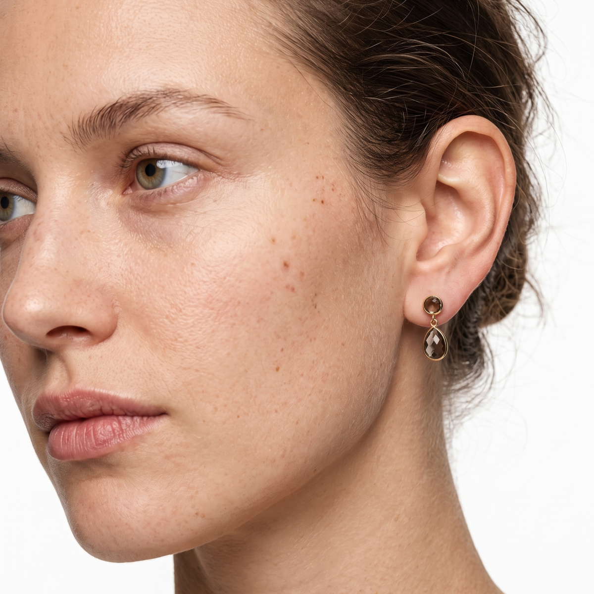 Model wearing gold smoky quartz teardrop stud drop earrings, close-up on the ear