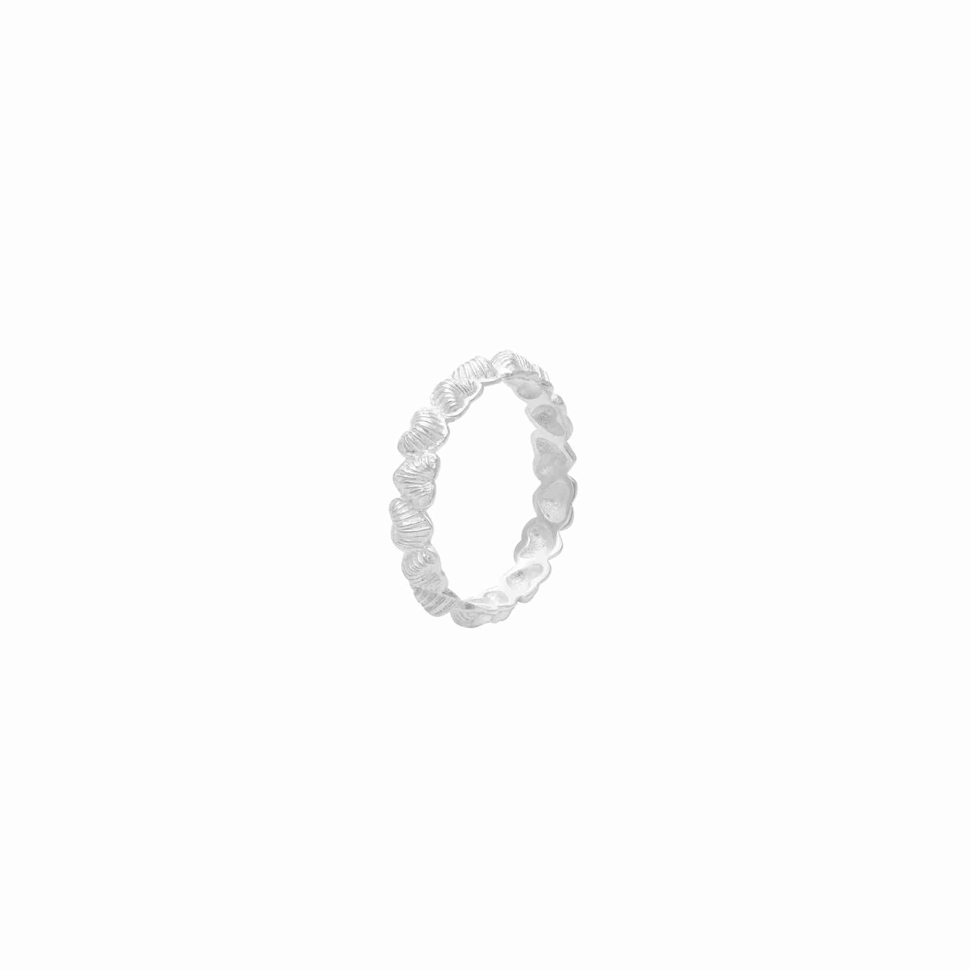 Three-quarter angled view of the silver Queen of Charms Fluted Hearts Eternity Band, highlighting the ribbed texture on the outer heart pattern and the hollowed back design of the band.