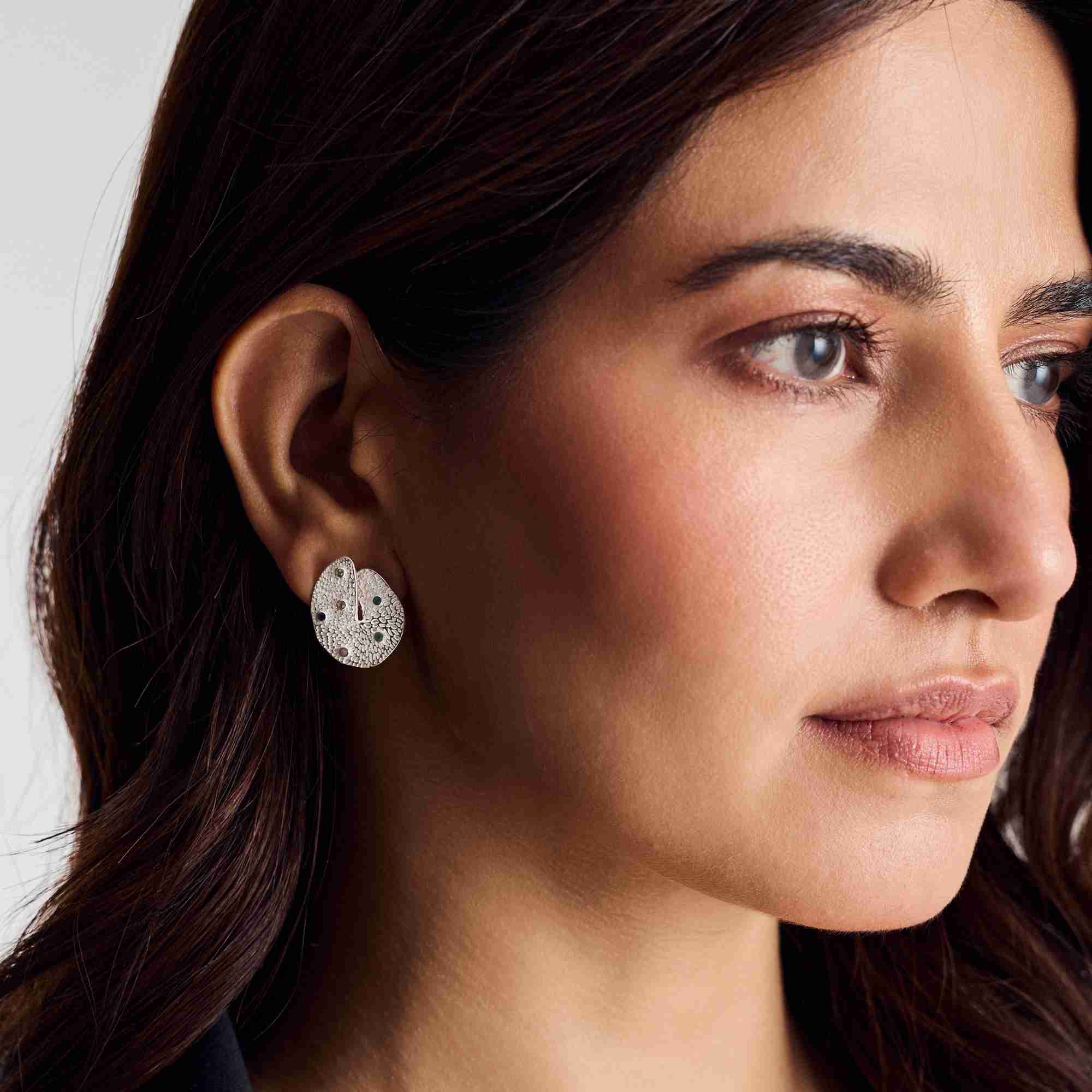 Three-quarter portrait shot of a model wearing the sterling silver Ribbons and Lace Galaxy Multi-Gemstone Stud Earrings.
