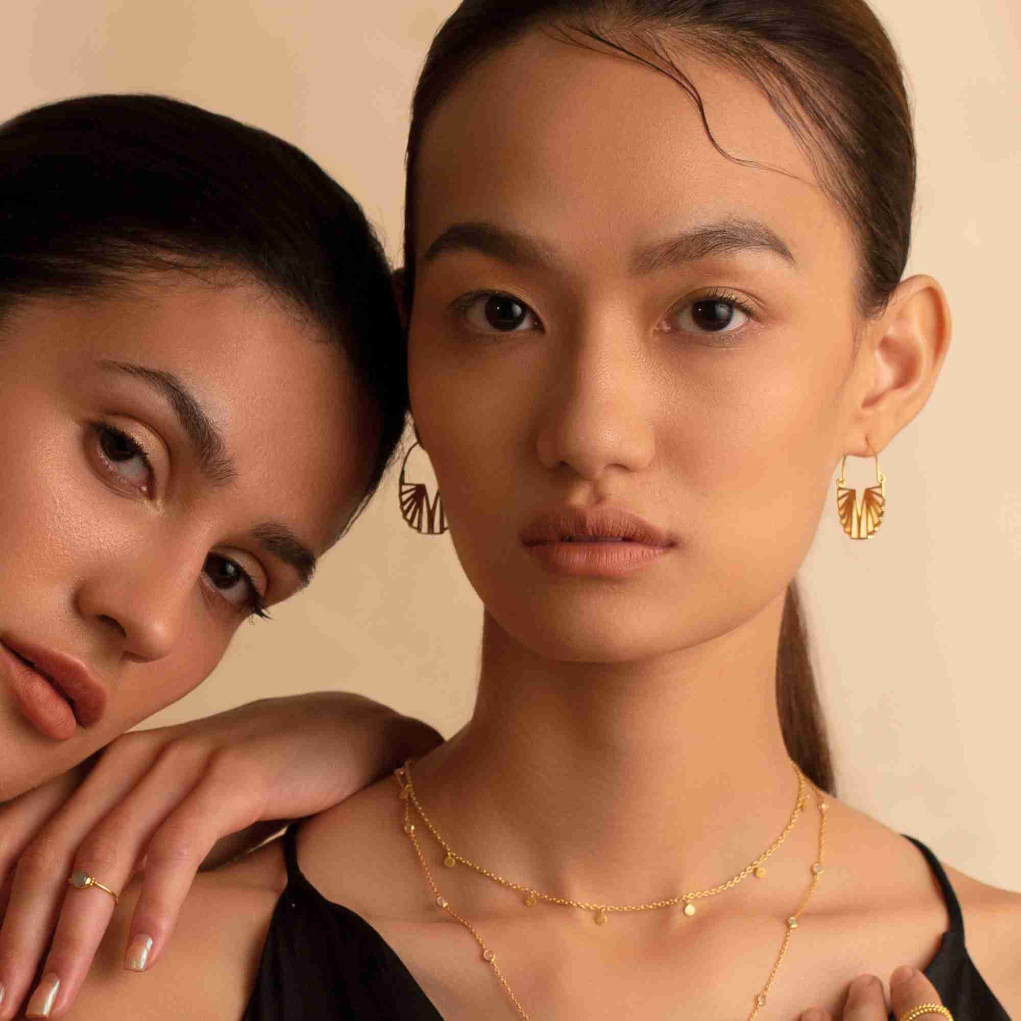 Model shot named Shimmering Disks (59).jpg showing a woman wearing the Shimmering Disks Constellation Disc Chain Necklace Gold; a delicate gold chain necklace adorned with miniature dangling disc charms by Protsaah Zurich.
