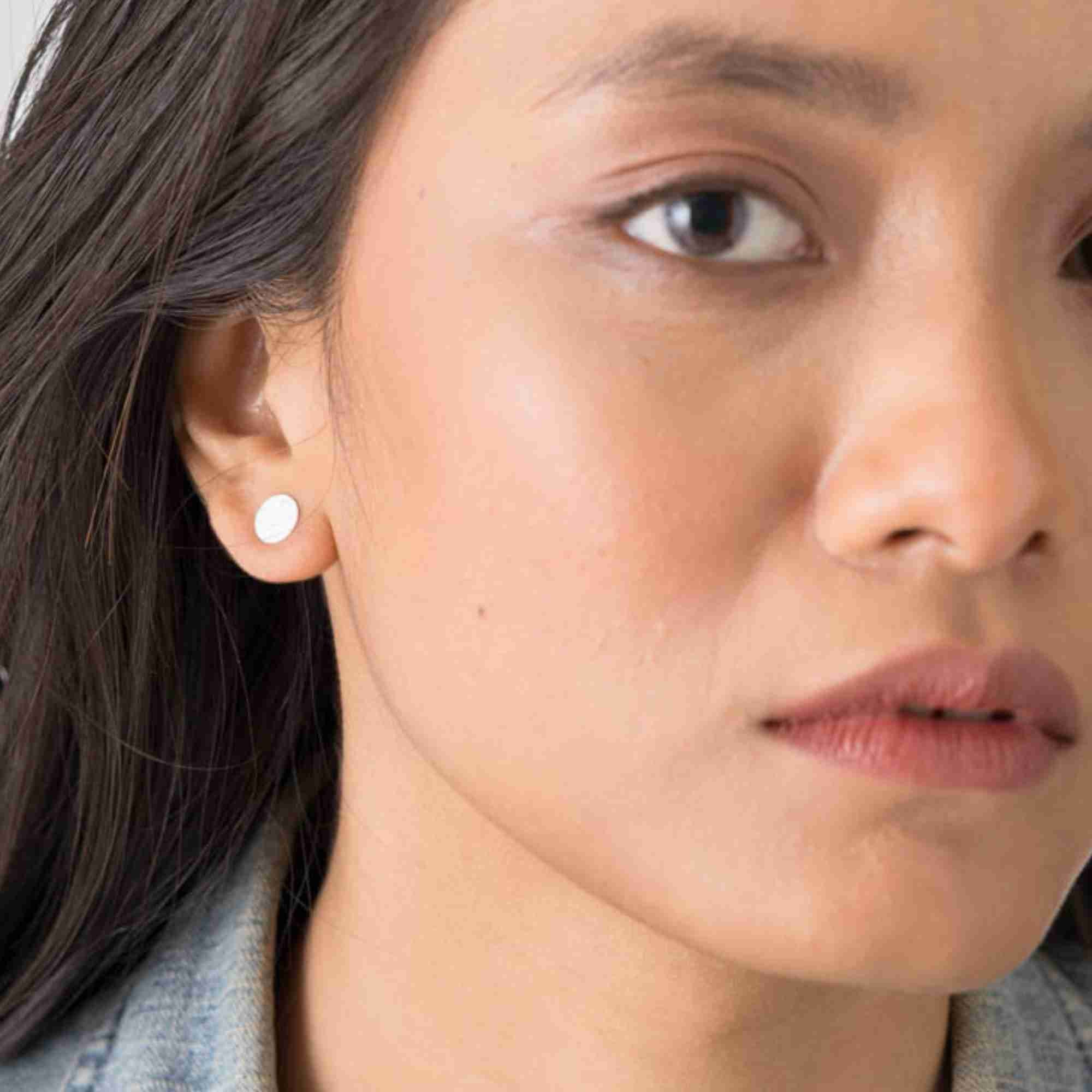 Front-angled view of a model styled with the silver Shimmering Disks Minimalist Stud Earrings for everyday wear.