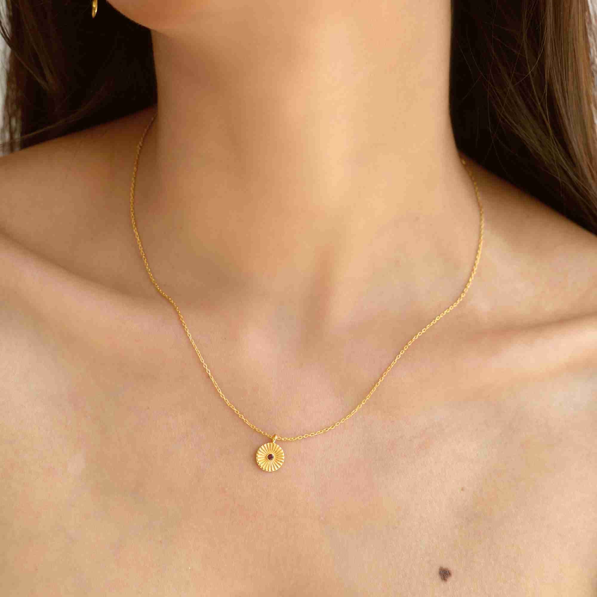 Lifestyle portrait focusing on the collarbone area of a model wearing the Delicate Vintage Labradorite Fluted Medallion Coin Pendant Necklace Gold, referencing file name Delicate_Vintage_2.jpg. The minimal gold medallion pendant hangs symmetrically, offering an elegant accent piece for everyday accessorizing.